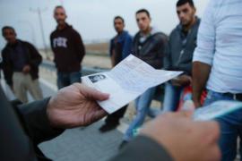 Poliziotti israeliani controllano i documenti di lavoratori palestinesi