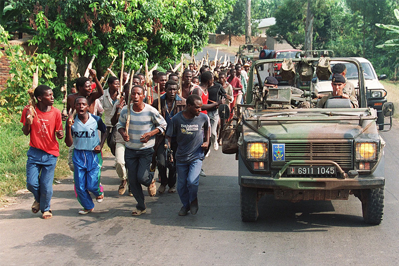 French soldiers on patrol pass by ethnic Hutu government troops near Gisenyie, 27 June 1994.